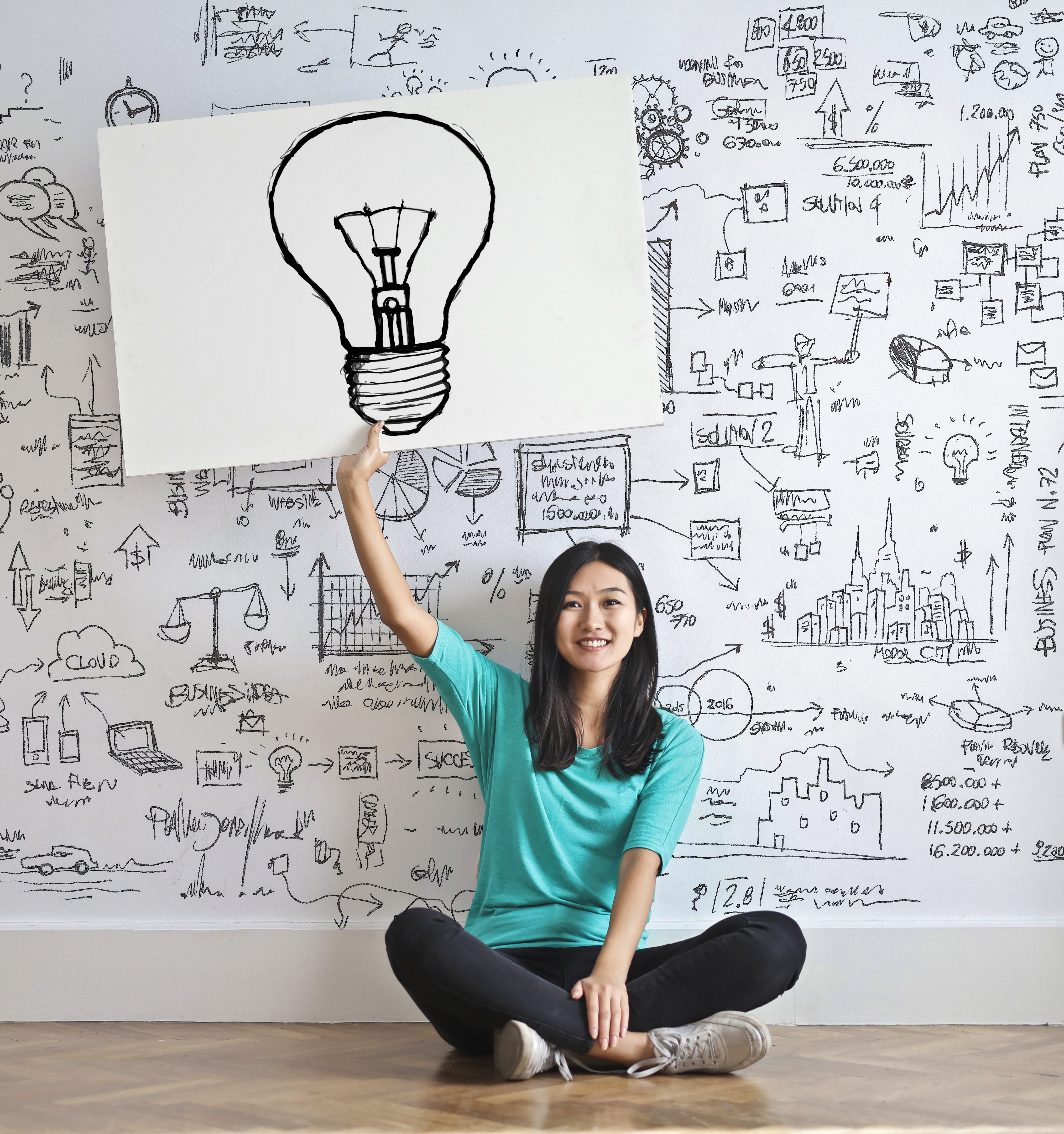 How to write a short story : woman draw a light bulb in white board