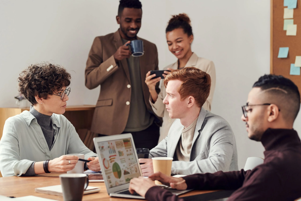 How to write story dialogue - A team engaging in discussion and collaboration at a workspace. Photo by fauxels from Pexels: