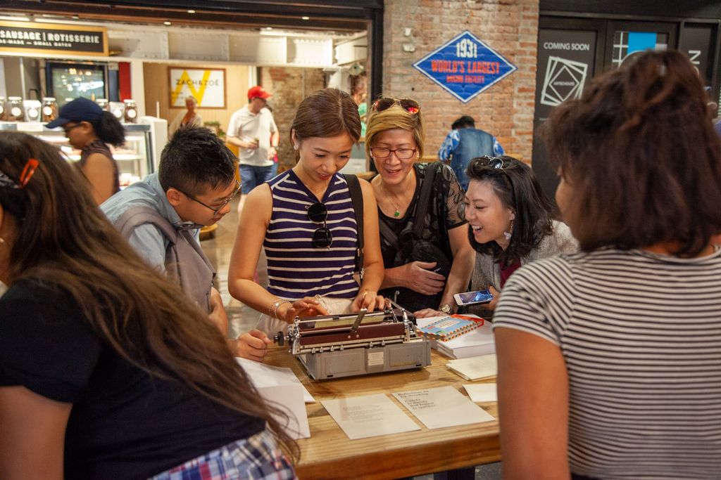 A group of people standing around a table looking at books.