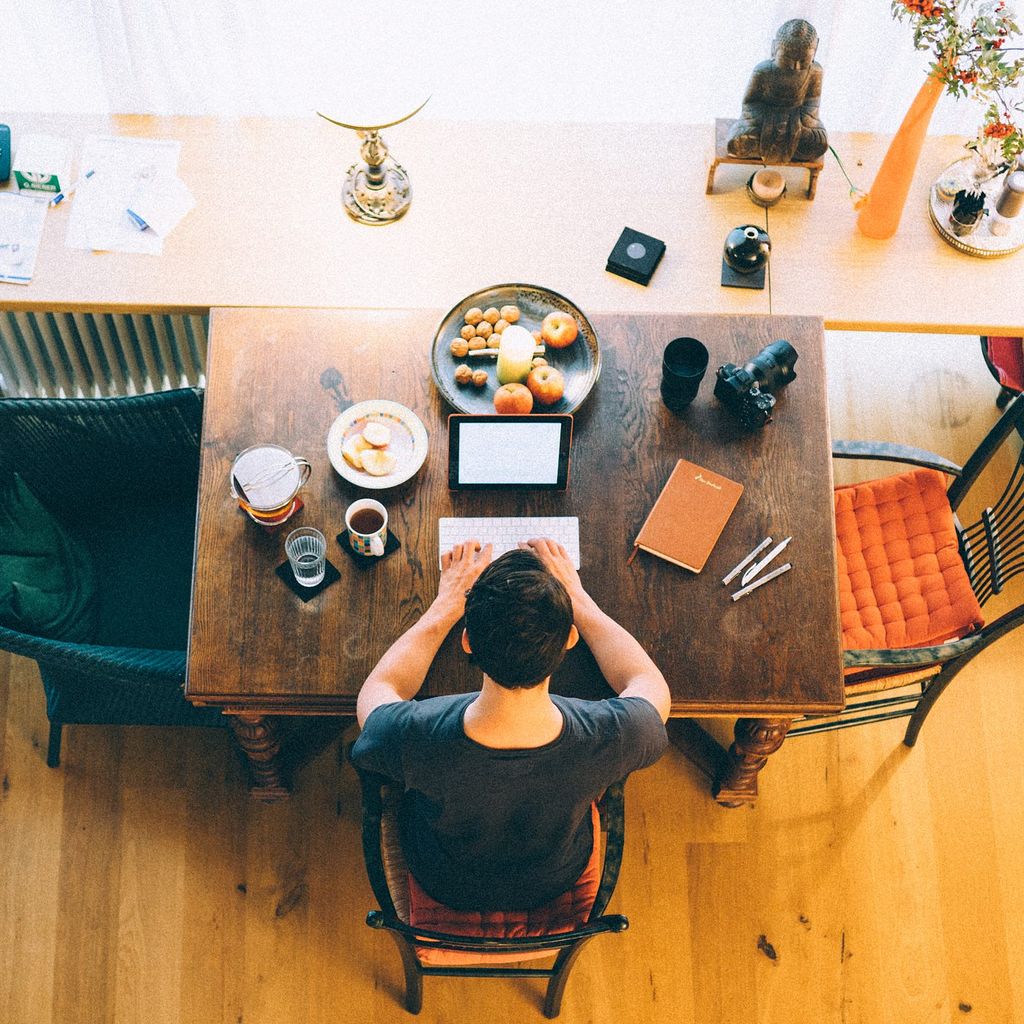 A man sitting at a table with a laptop.